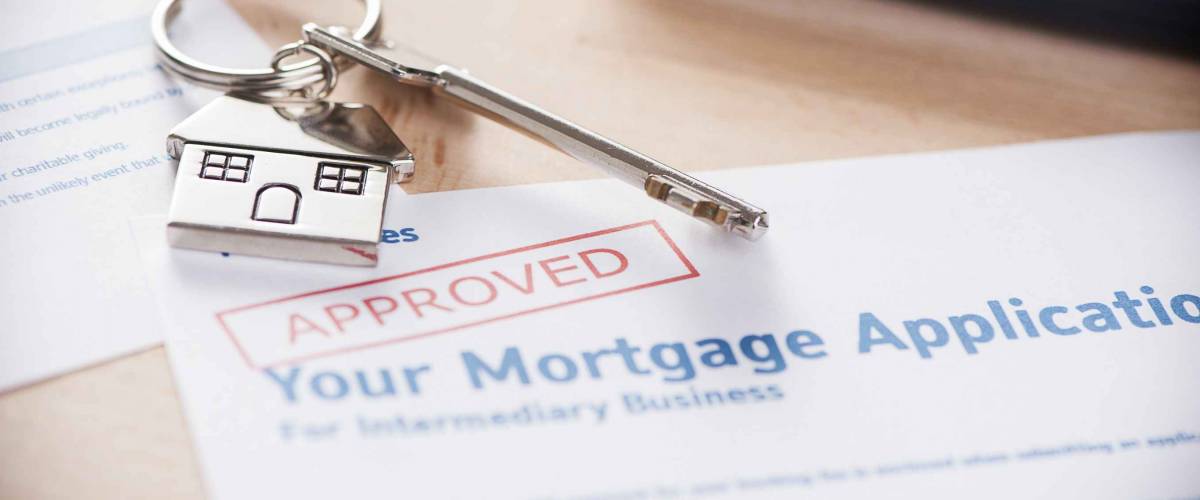Approved mortgage loan agreement application with house shaped keyring