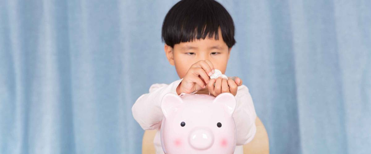 Cute three-year-old girl sorting out her pocket money