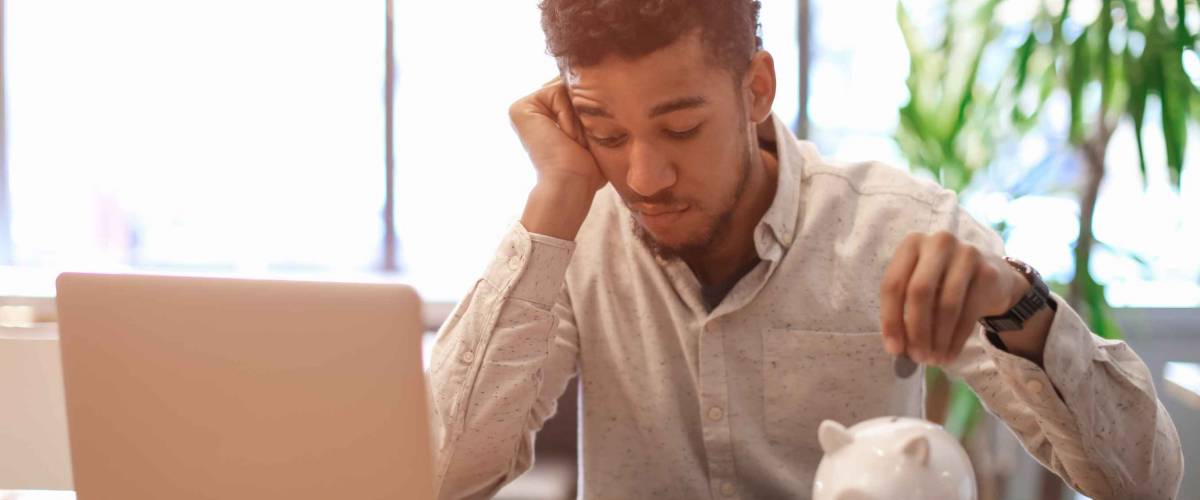 African-American man counting savings at table
