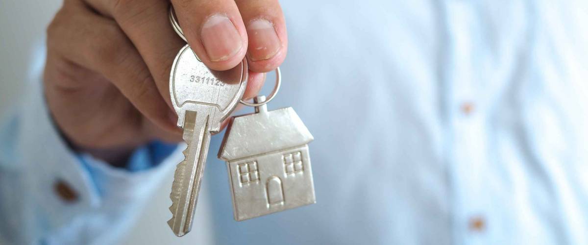 A business man with a house key. sale house concept