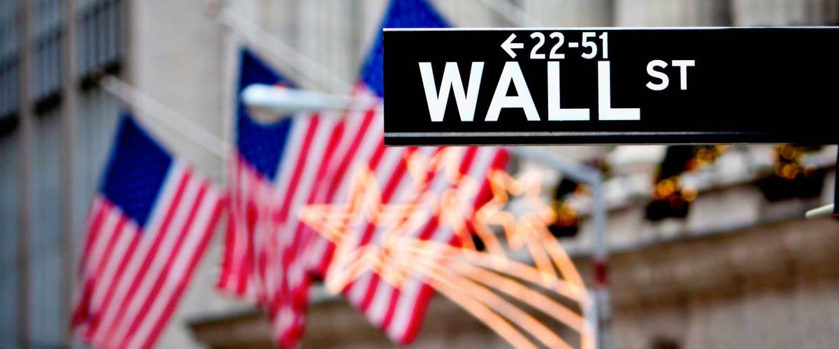 Wall street sign in New York with New York Stock Exchange background