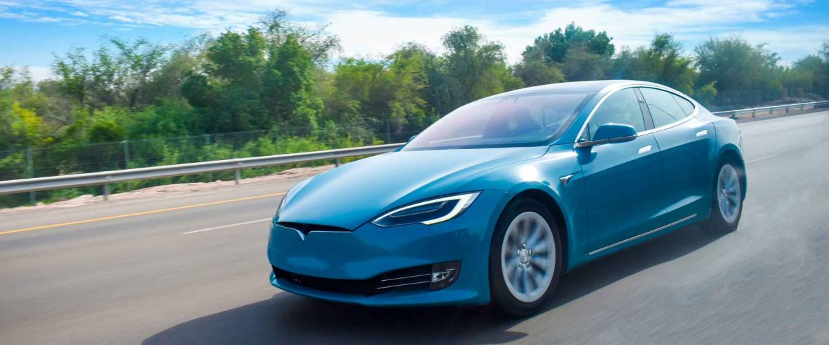 An electric car cruising on highway,with clear blue sky.green energy concept.Have space for text.