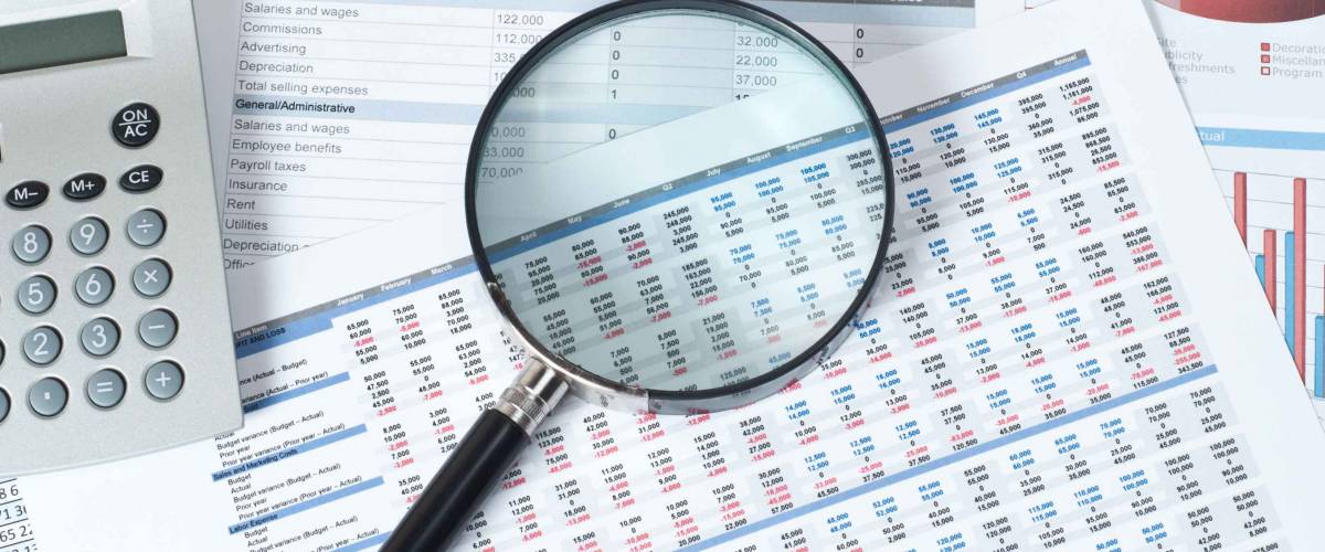 financial documents with magnifying glass over them