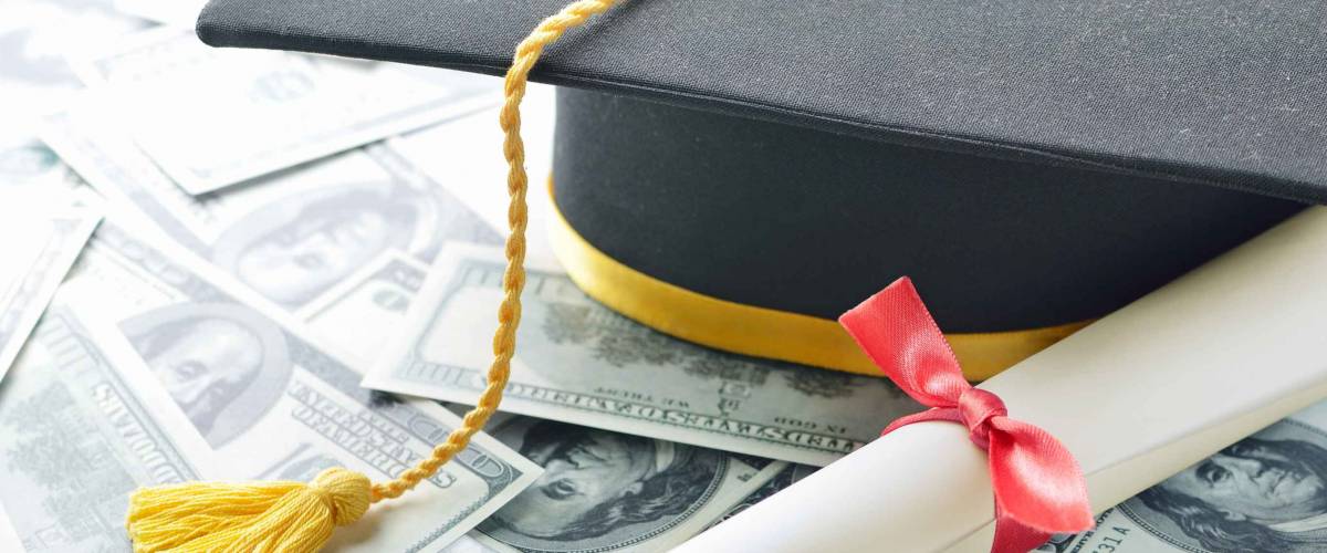 Graduation hat with diploma and money