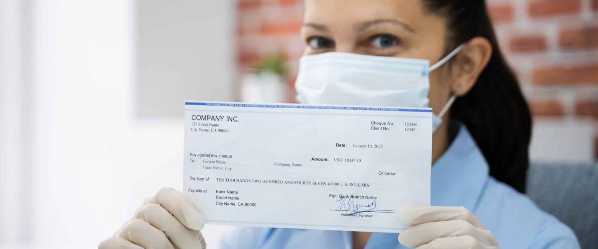 Woman In Face Mask Holding Paycheck Or Stimulus Check