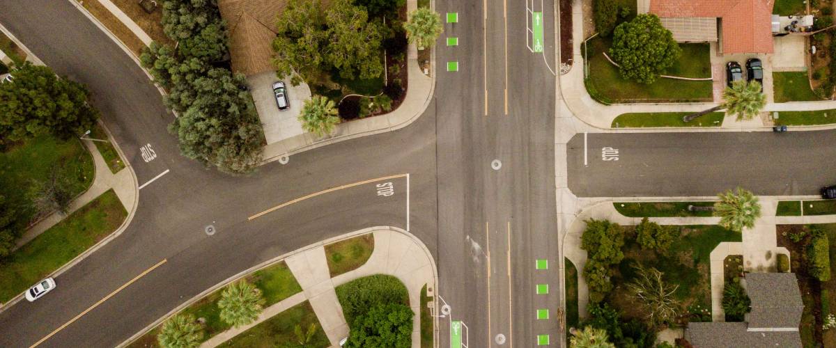 aerial drone view of a suburban neighborhood street and intersection