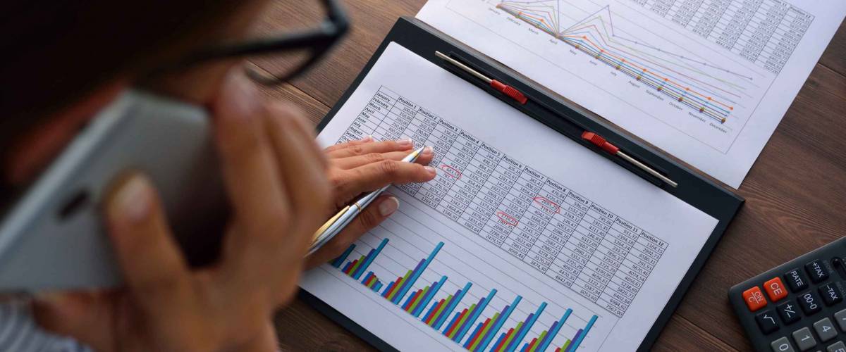 Woman looking at numbers, graphs while on a cellphone