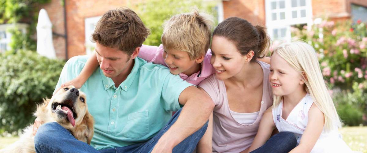 Family Sitting In Garden Together