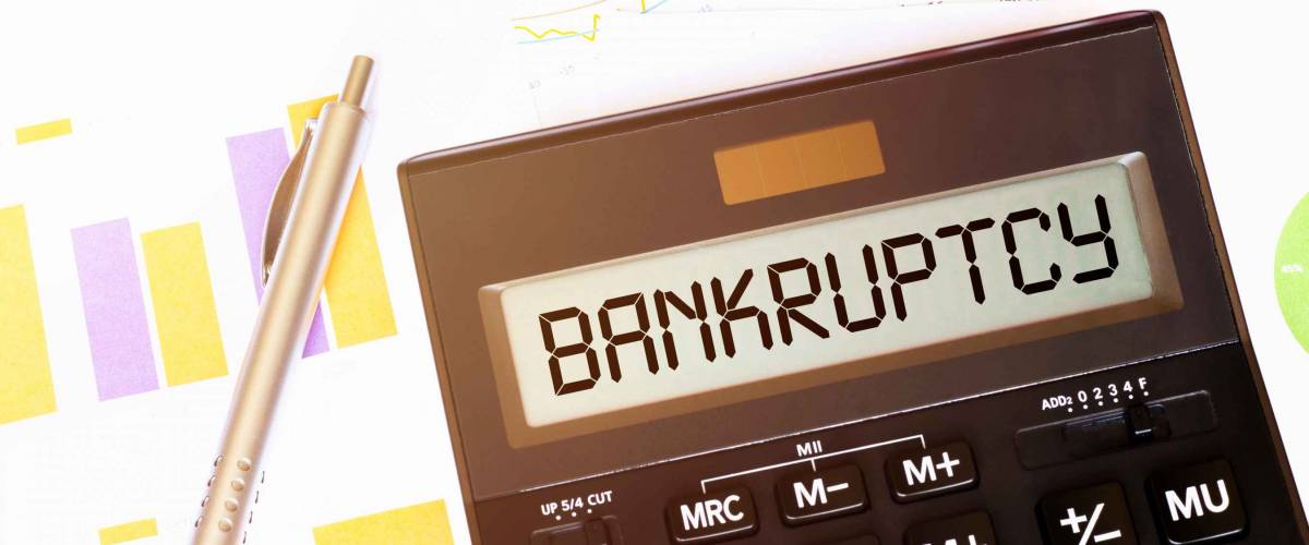 Word BANKRUPTCY plus on calculator. Business and tax concept