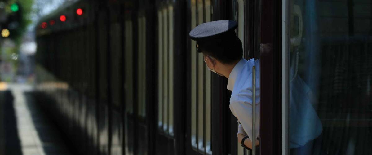 The train conductor watching at the platform.
