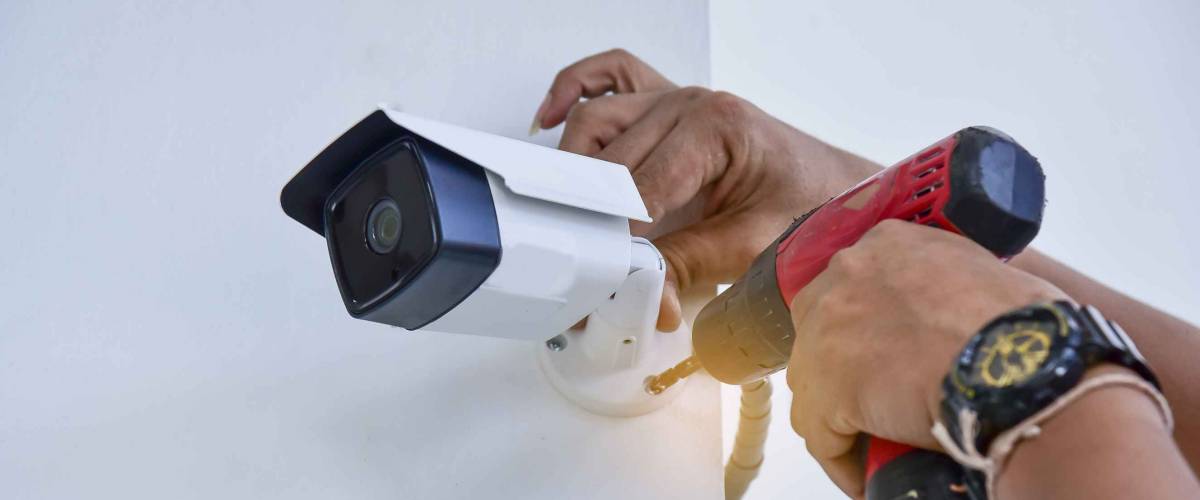 Technician installing CCTV camera for security