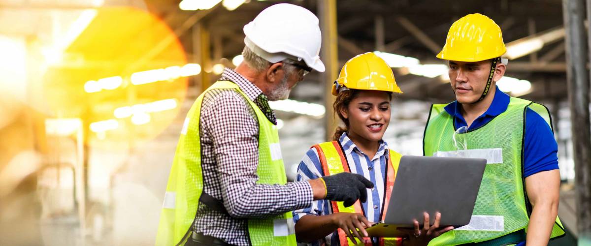 Professional Mechanical Engineer team Working on Personal Computer at Metal lathe industrial manufacturing factory. Engineer Operating lathe Machinery. Product quality Inspection