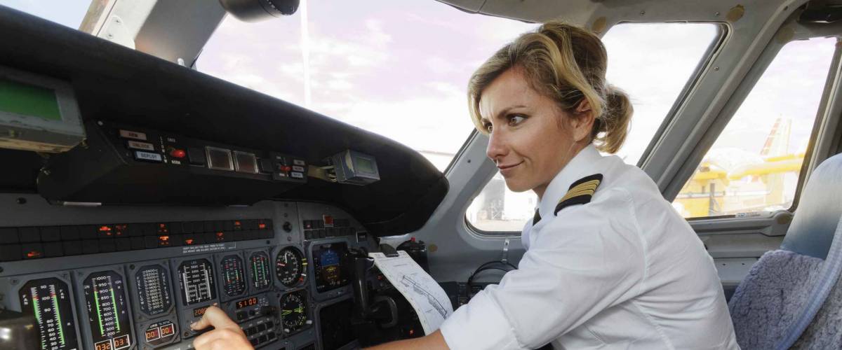 Italy, female pilot in an airplane's cockpit