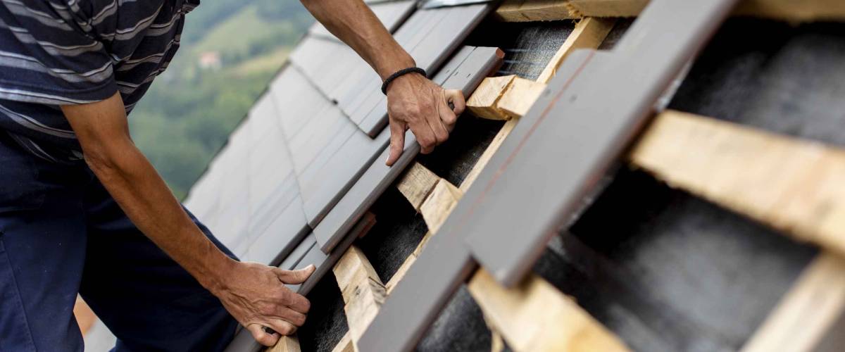 Man laying shingles on roof