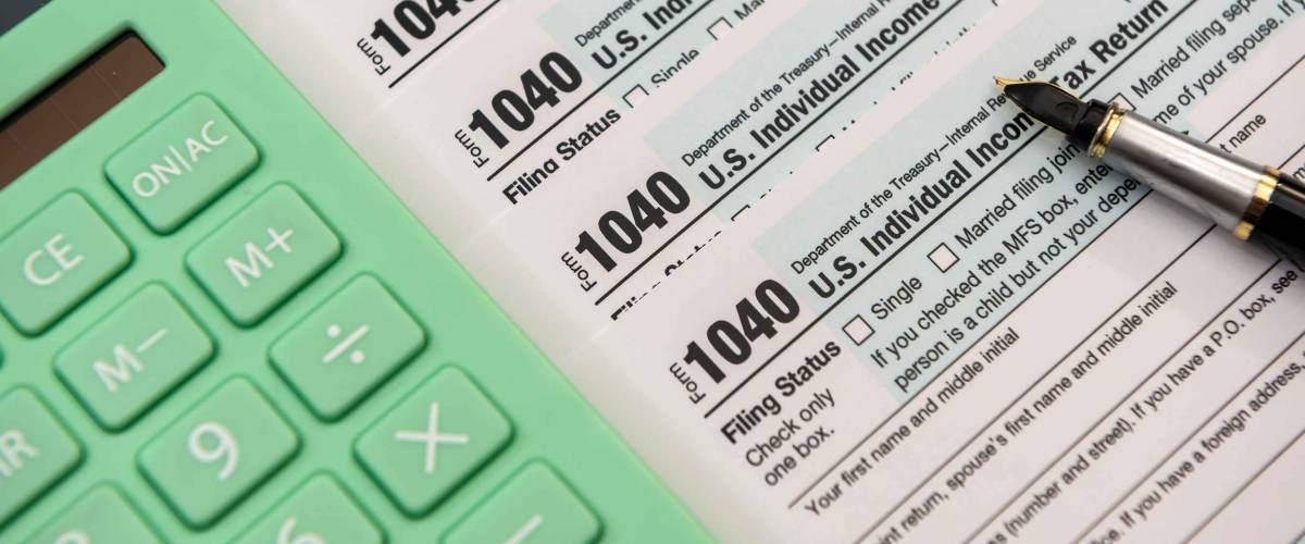 paperwork 1040 individual income tax form document with pen and calculator