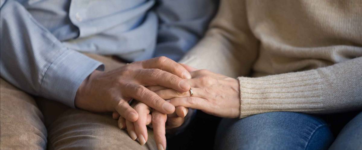 Close up of older man and woman holding hands