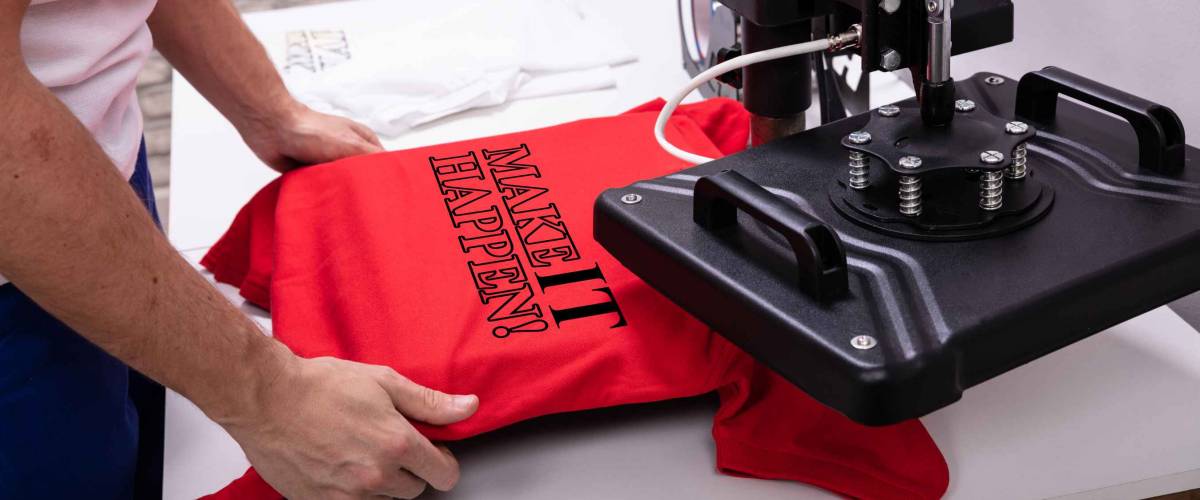 Man printing on t shirt in workshop