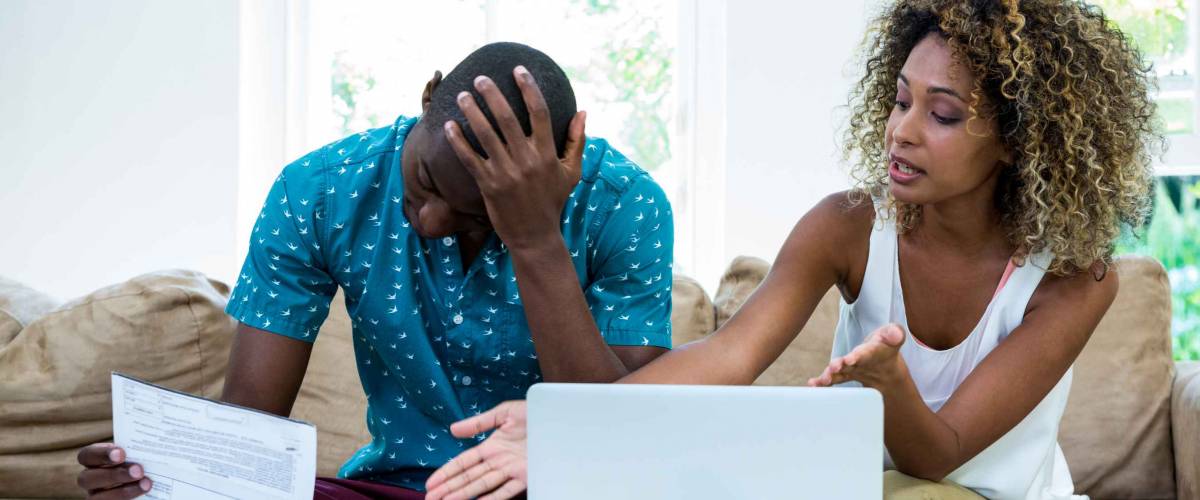 Worried young couple discussing on bills at home