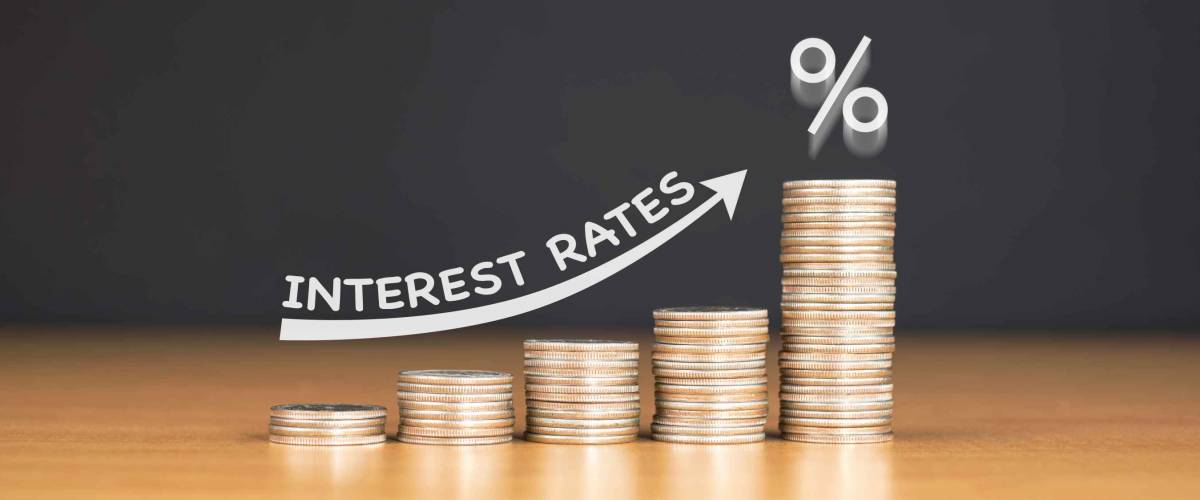 STACKED US QUARTER COINS ON WOODEN TABLE WITH WHITE ILLUSTRATION SHOWS INCREASING OF INTEREST RATES / FINANCIAL CONCEPT