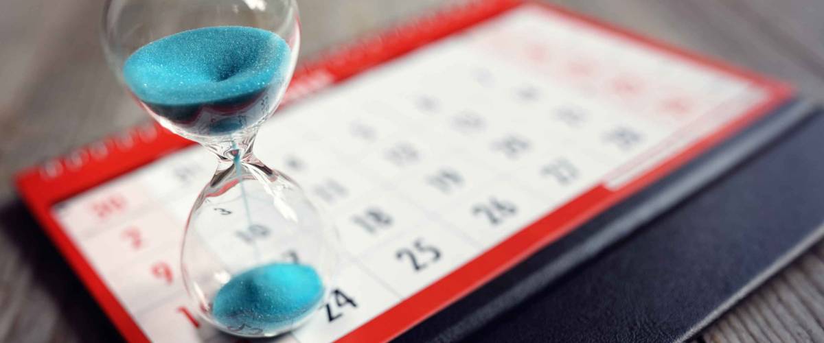 Hour glass on calendar concept for time slipping away for important appointment date, schedule and deadline