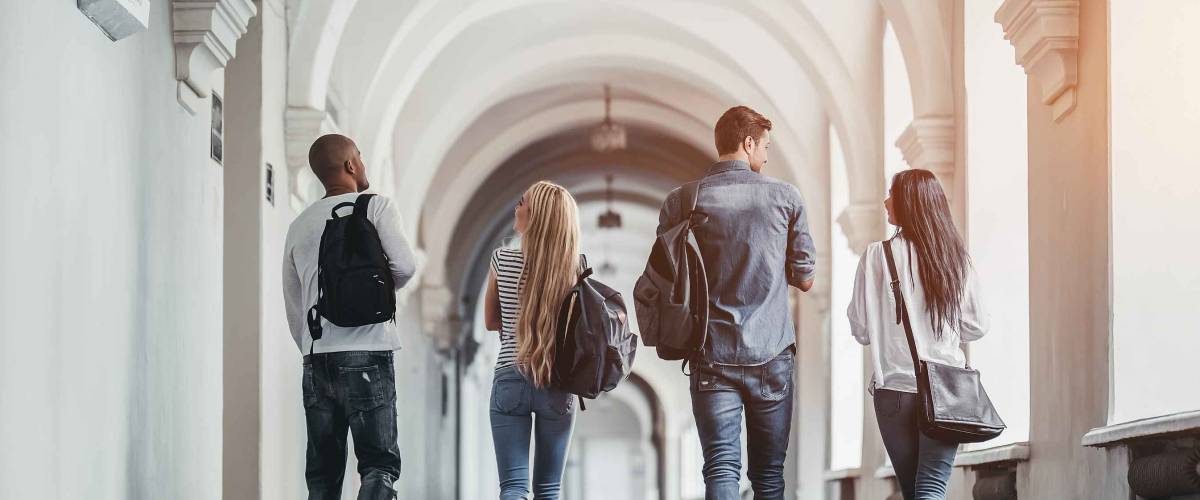 Students walking down school hall, seen from behind