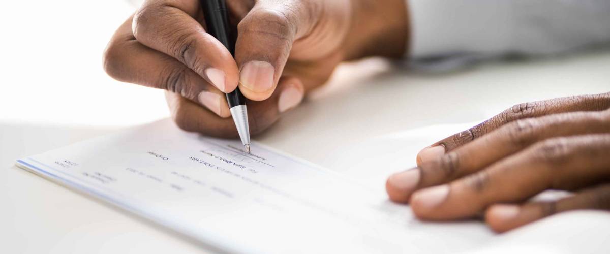 Close up of man's hands writing a check