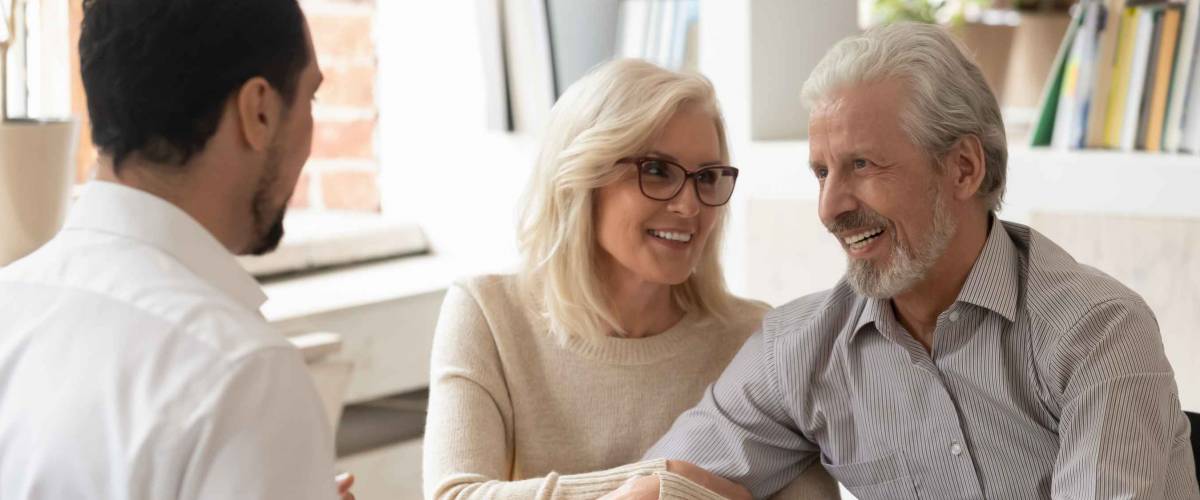 Older couple sit across a table from young man