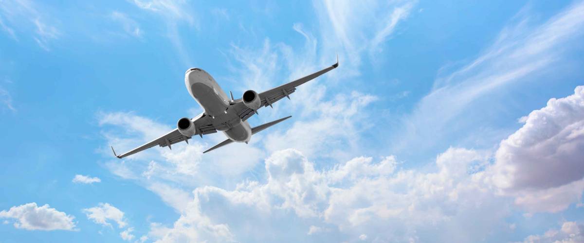 White passenger airplane over the clouds - Travel by air transport