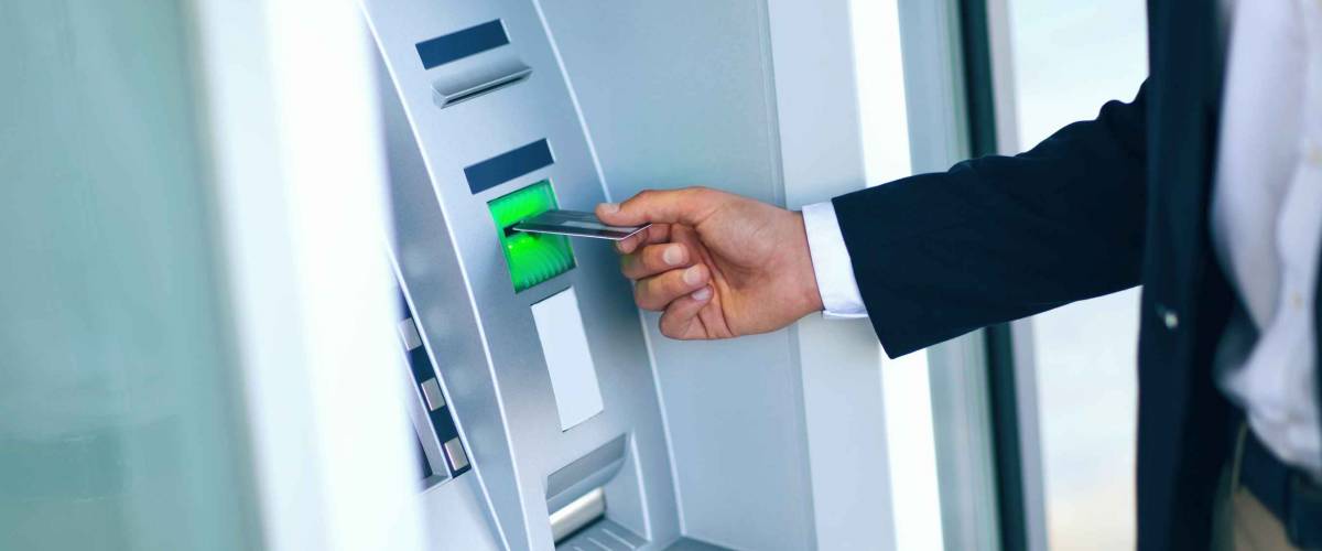Close-up Of Person Using Credit Card To Withdrawing Money From Atm Machine