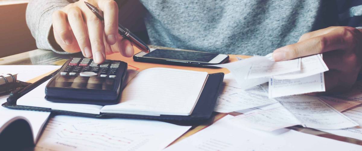 Man using calculator and calculate bills in home office.