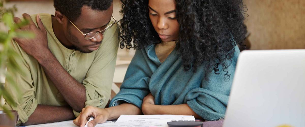 Couple sitting together and reviewing financial documents at a table