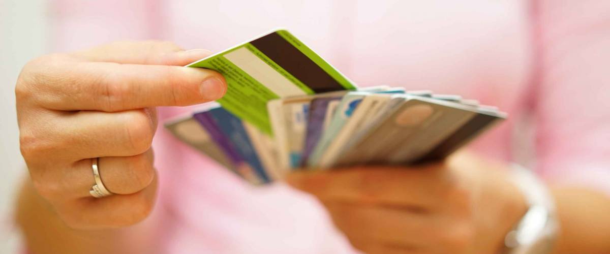close up of woman's hands holding multiple credit cards fanned out