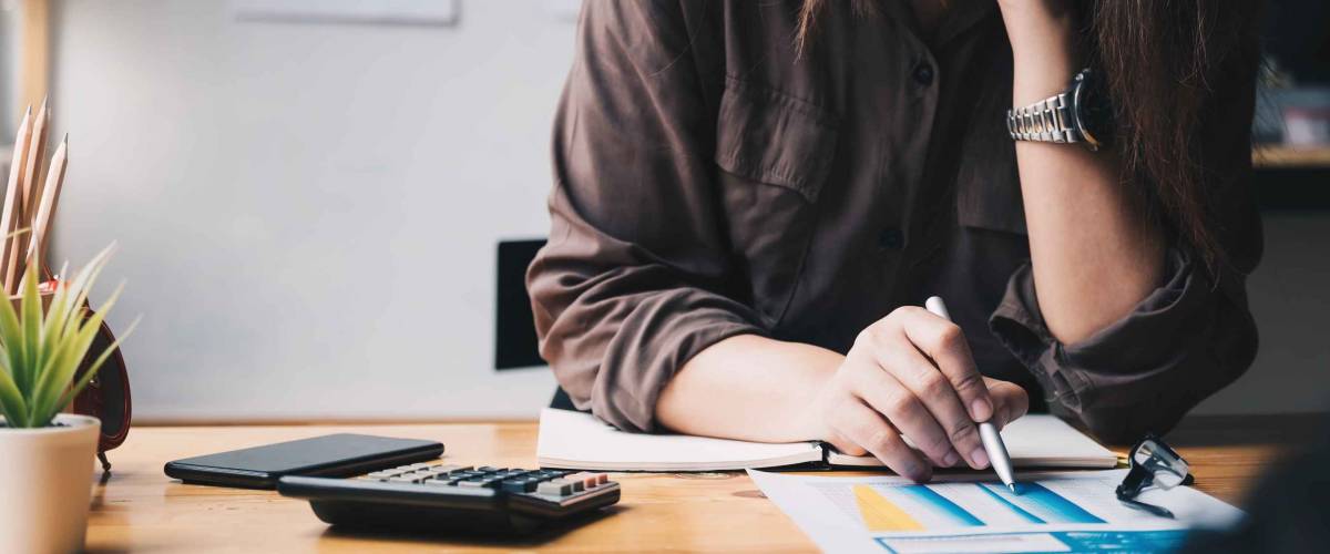 Woman writing notes on chart with pen