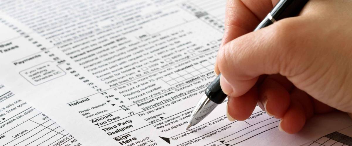 tax form with hand and pen