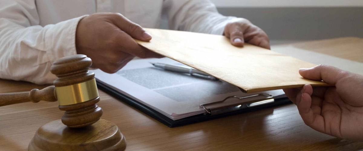 Close up of two people in lawyer's office trading papers