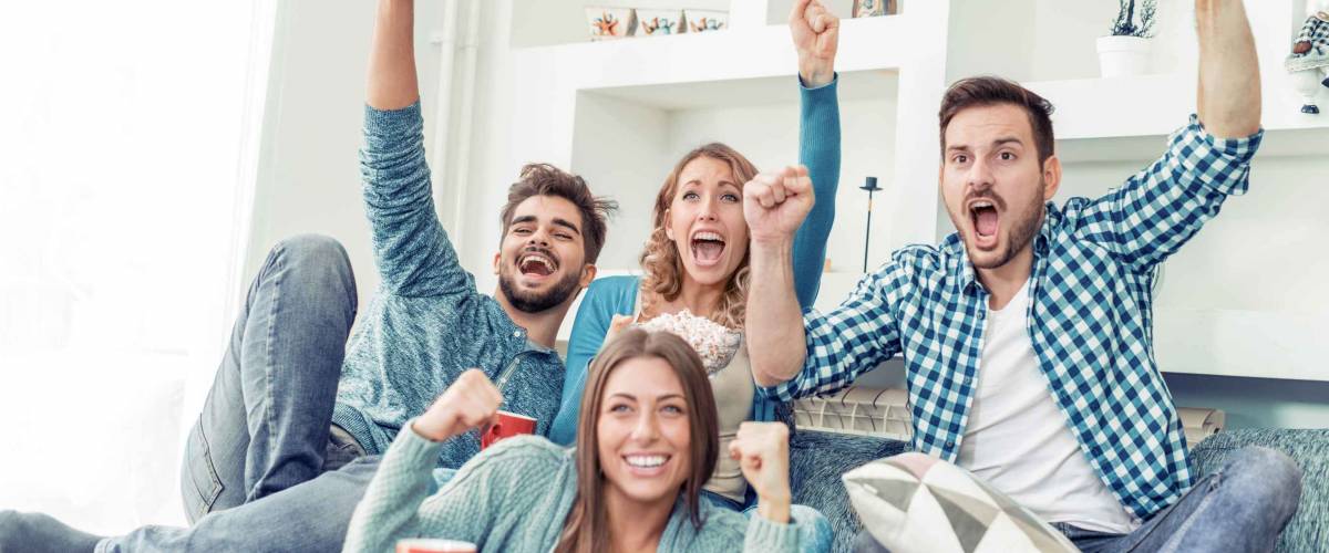 Group of friends having fun at home,watching game and enjoying together.