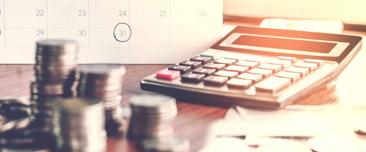 debt collection and tax season concept with deadline calendar remind note,coins,banks,calculator on table, background ,time to pay concept