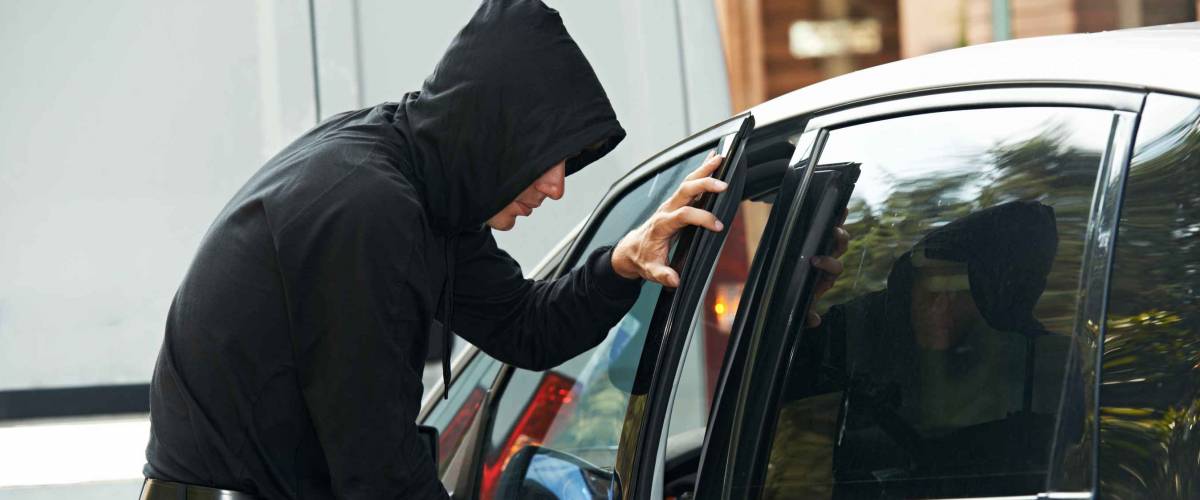 Thief stealing automobile car at daylight street in city