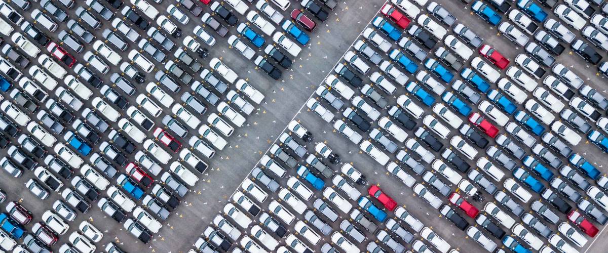 Aerial view new car lined up in the port for import and export business logistic to dealership for sale, Automobile and automotive car parking lot for commercial business industry.