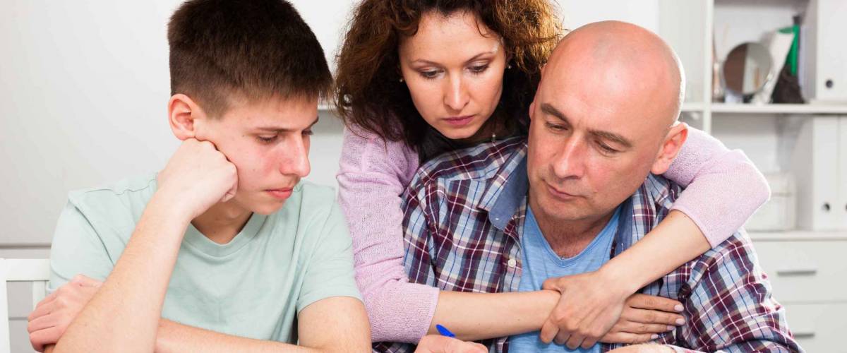 Portrait of family with teenage son working with papers at home