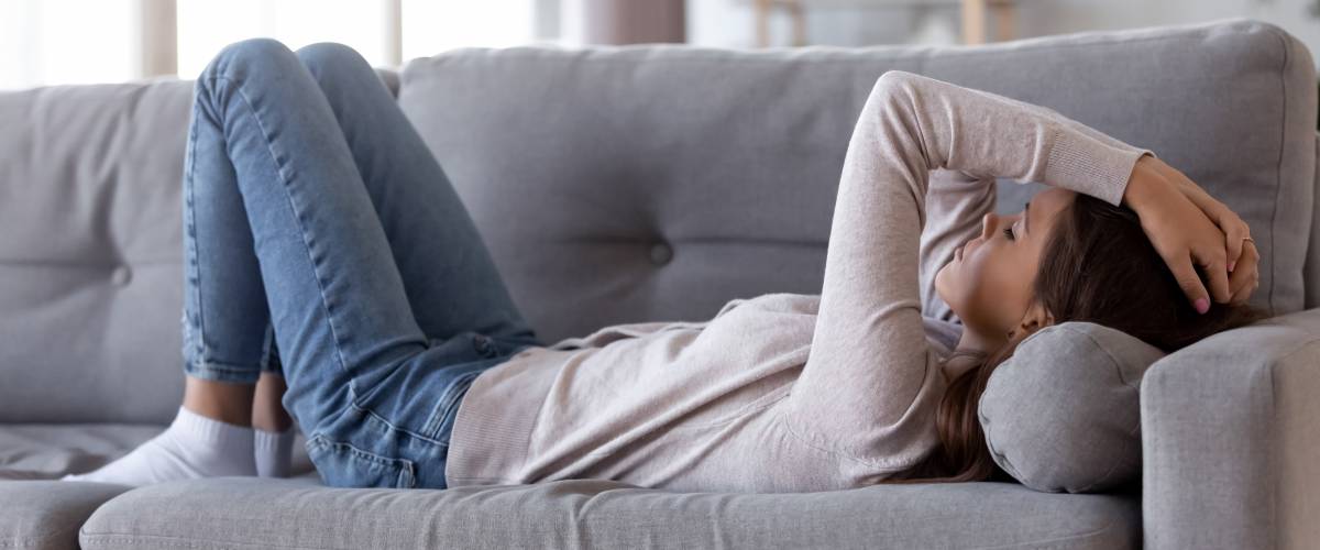 Stressed woman lying on couch