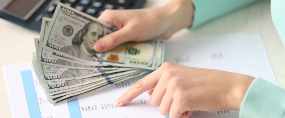 Woman counting money at the table