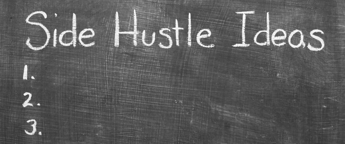 “Side Hustle Ideas” handwritten on blackboard. Copy space.