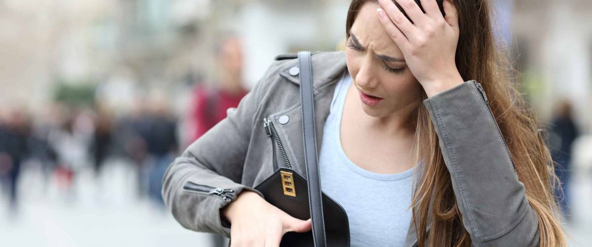 Front view of a worried woman looking preoccupied inside her bag on a city street