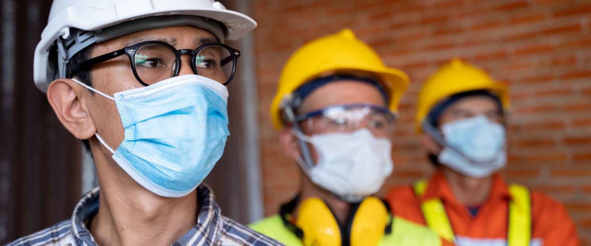 Industrial engineering team wears a COVID 19 protective mask. Workers wear a quarantine mask to prevent the spread of Covid 19 by wearing a face mask. Coronavirus disease.