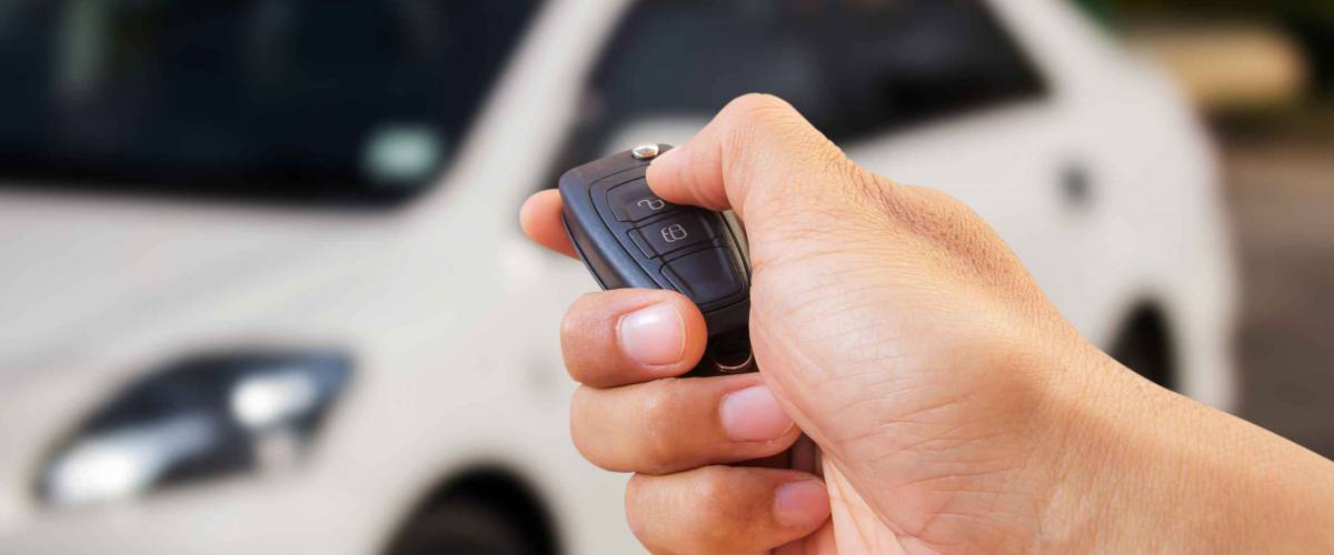 Men's hand presses on the remote control car alarm systems