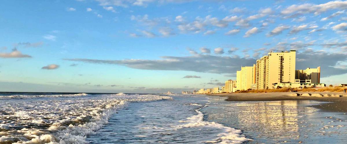 Beautiful beach scenery in a sunny day, blue sky with white clouds, in North Myrtle Beach, South Carolina. Oceanfront modern resorts