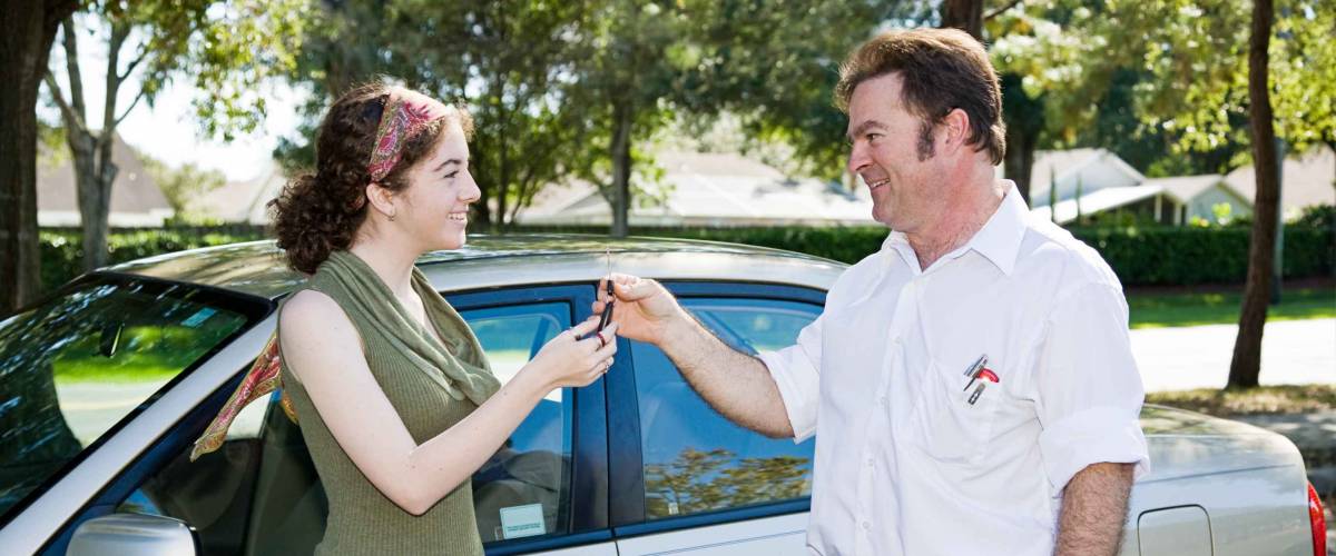 Man giving young woman car keys