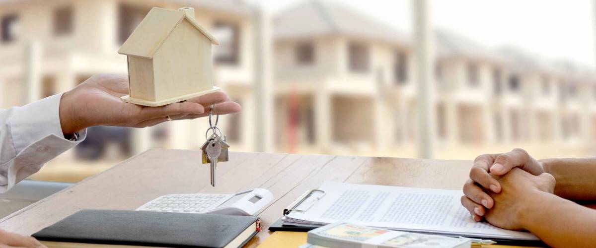 The businessman is handing the house keys to the contracted client