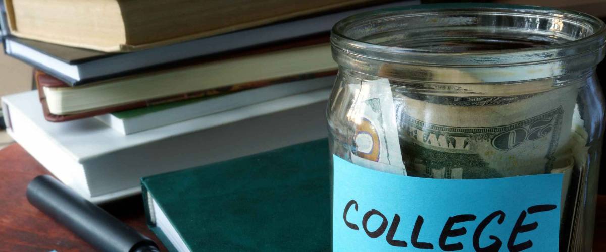 Jar with label college and money on the table.